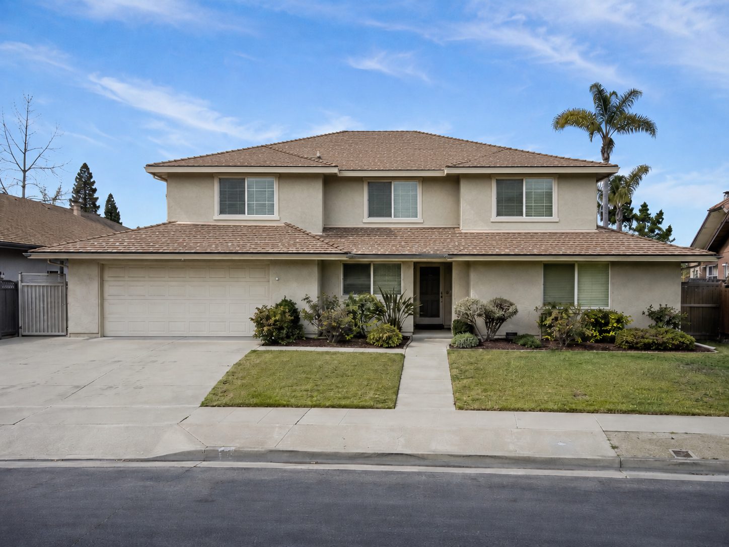 The same house with a full second storey added above the main body, three new upper windows, and a new tile hip roof