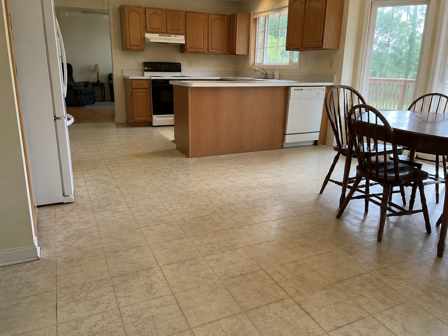 Kitchen and dining area with old patterned vinyl flooring, the cabinets and counters in place
