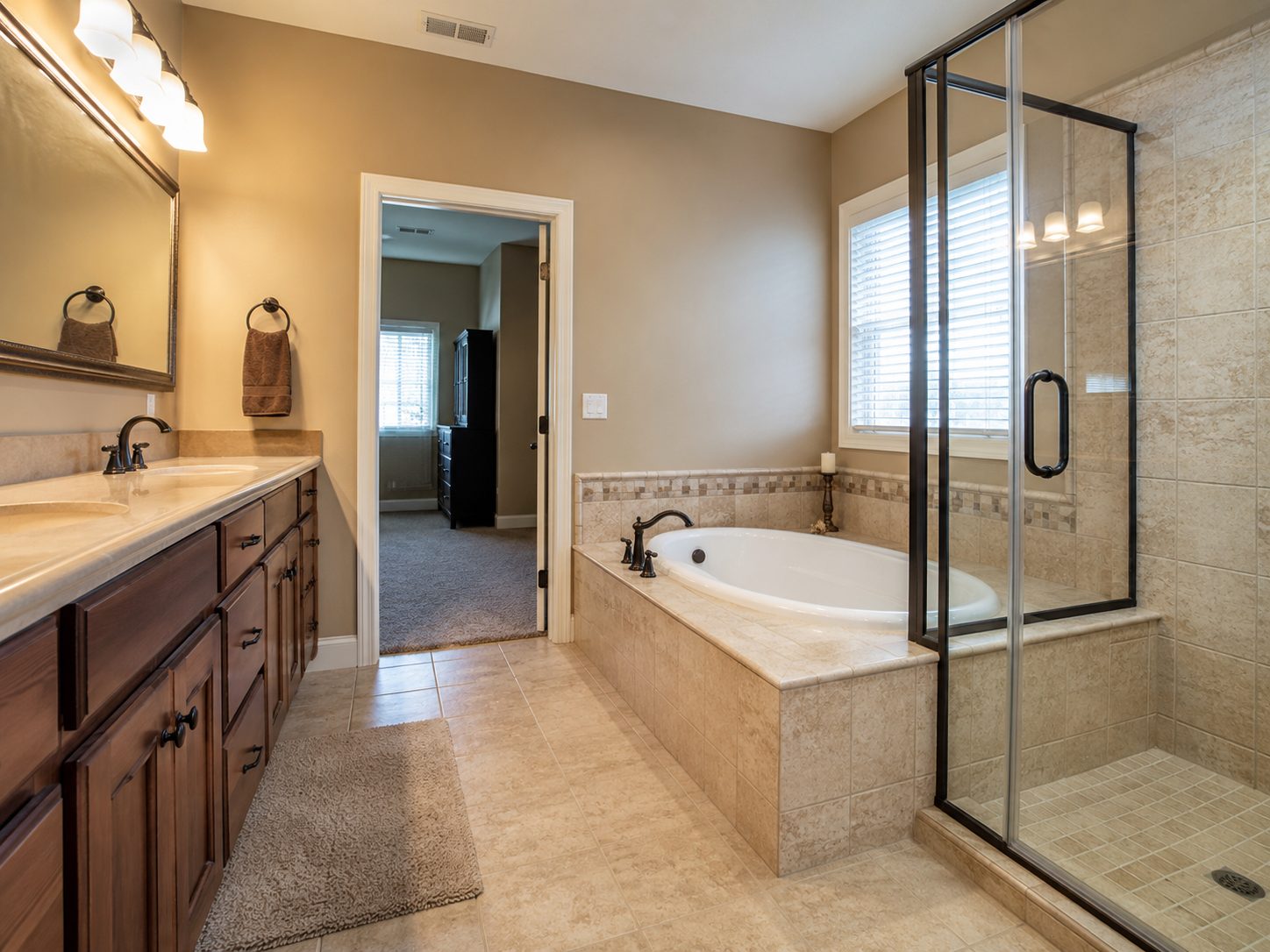 Bathroom with a built-in tub, beige tile, and a dark wood vanity before remodeling