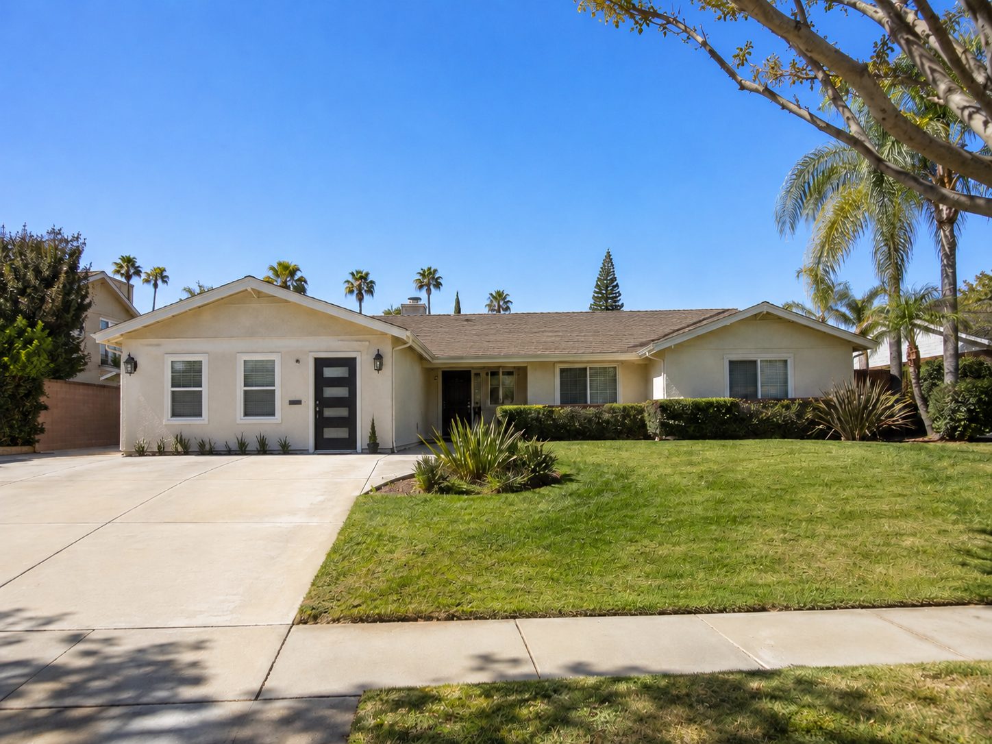 The same gable with the garage door removed and replaced by stucco wall, two white framed windows, and a dark modern entry door