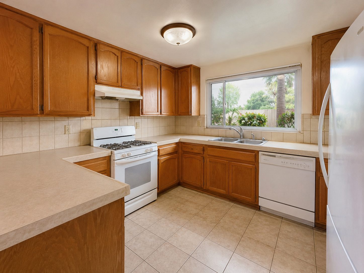 Corner kitchen with oak cabinets and a white stove before remodeling