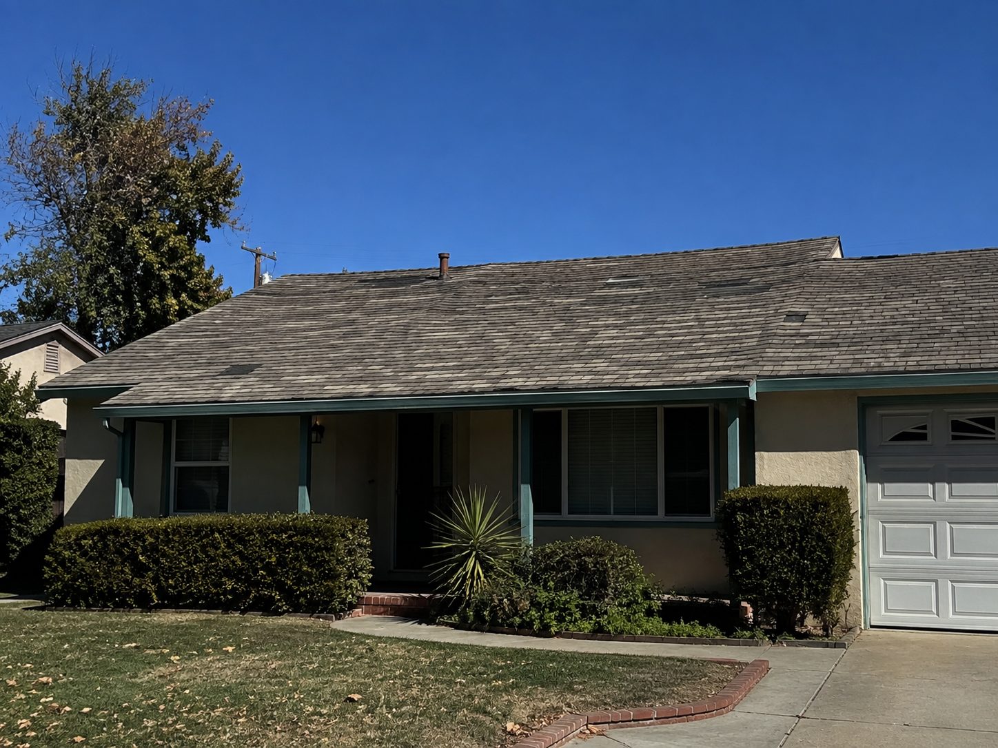 Sloped elevation covered in worn wood shake with split and lifting courses