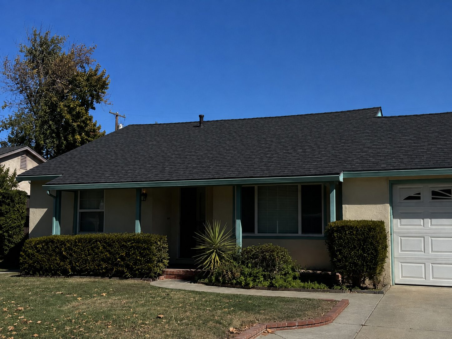 The same sloped elevation covered in new charcoal architectural shingle