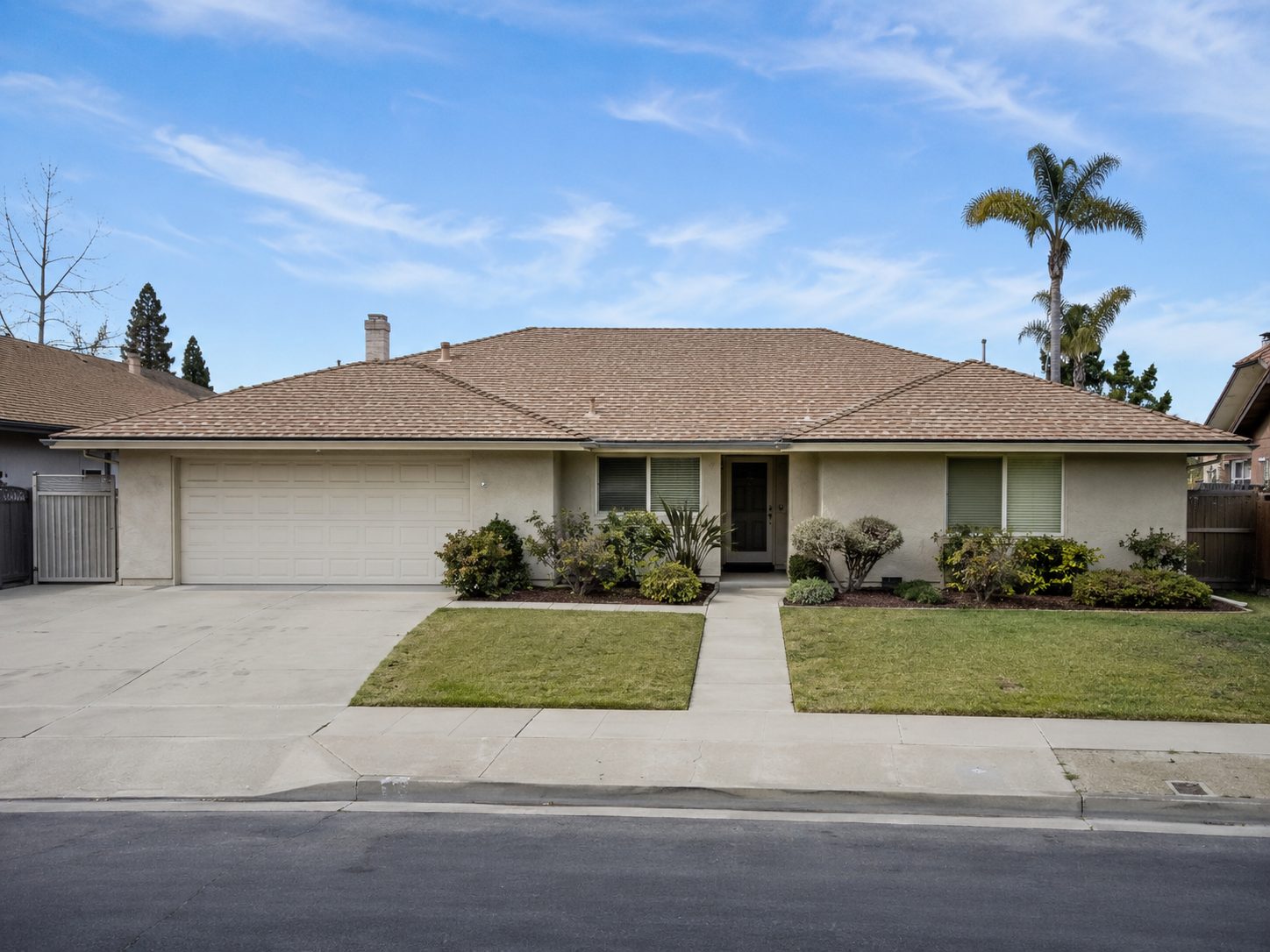 Single storey house with a tile hip roof, attached two car garage, and a lawn either side of the front walk