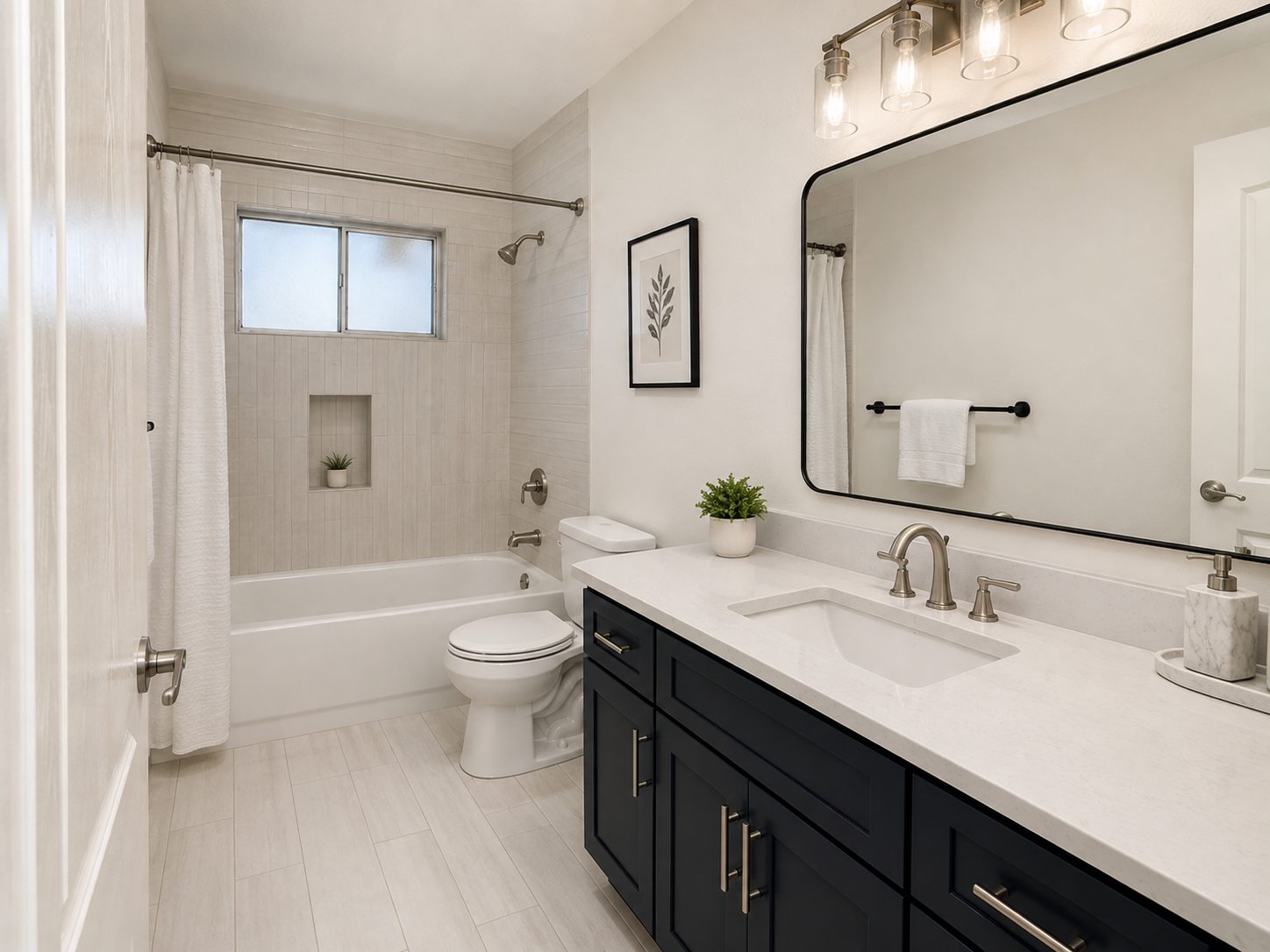 Remodeled bathroom with vertical white shower tile, a navy vanity, and a black-framed mirror