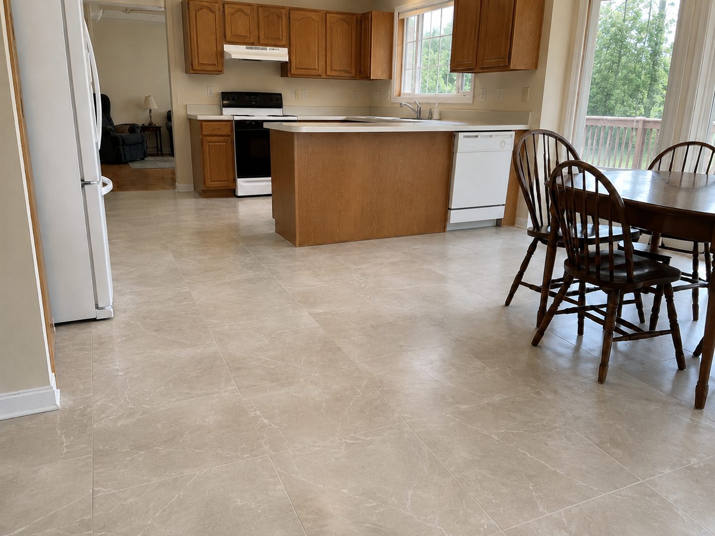 The same kitchen and dining area with large format tile flooring, the same cabinets, counters, and layout